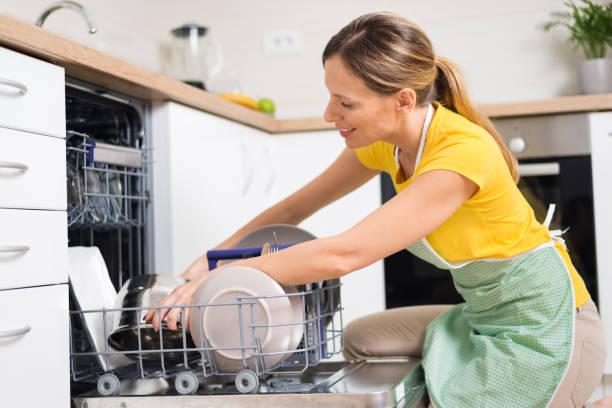 istock Smiling woman using dishwasher in the kitchen. 1017599116