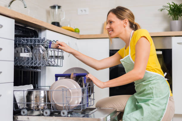 istock Smiling woman using dishwasher in the kitchen. 1017599136