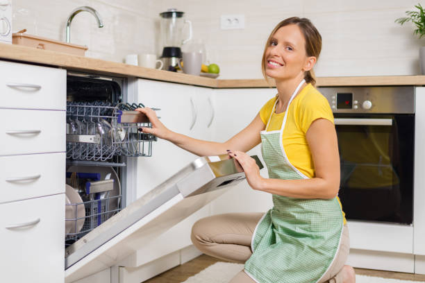 istock Smiling woman using dishwasher in the kitchen. 1017599180