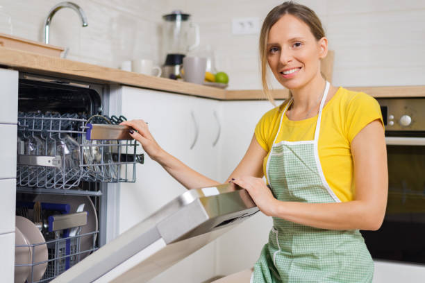 istock Smiling woman using dishwasher in the kitchen. 1017599196