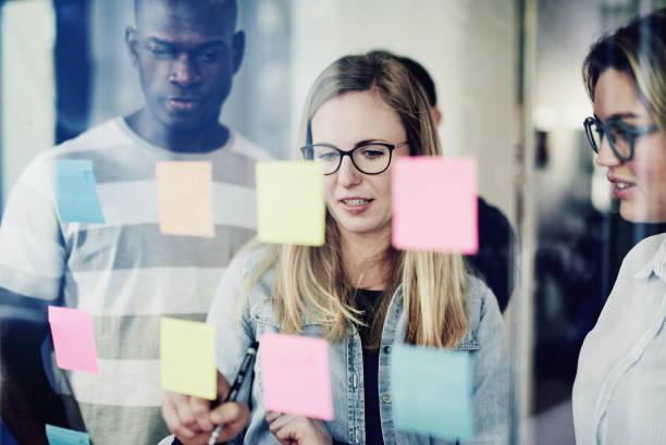 istock Diverse colleagues brainstorming with sticky notes on an office window 1017602852