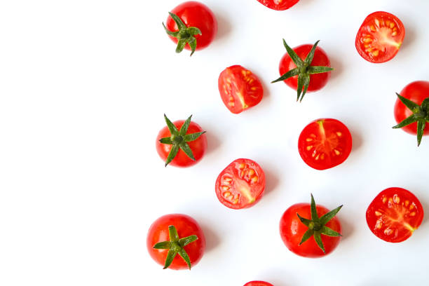 istock Minimalistic flat lay composition of shiny red cherry tomatoes reflecting light, laying on isolated white background 1017607248