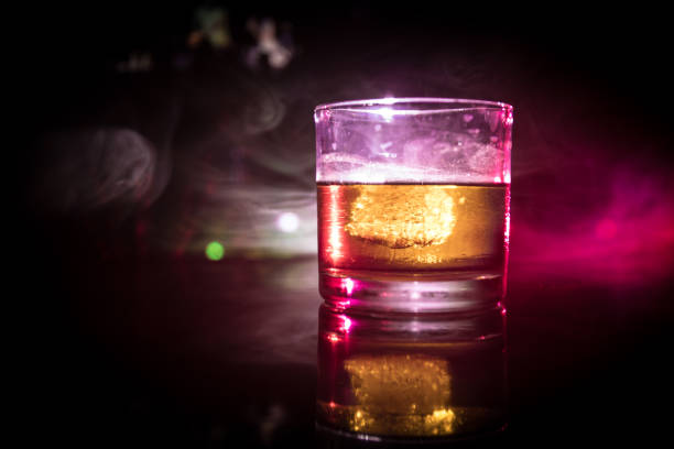 istock selective focus pure whisky with ice cube inside whisky glass on dark foggy background alcohol drink concept. 1017607666