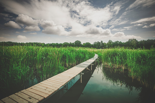 beautiful wooden jetty and cloudscape at lake beetzsee in brandenburg in the east of germany.