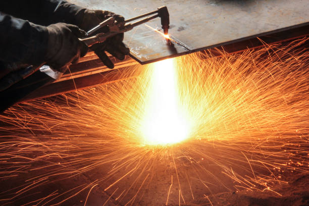 Oxy-fuel cutting. In oxy-fuel cutting, a torch is used to heat metal to its kindling temperature. A stream of oxygen is then trained on the metal, burning it into a metal oxide that flows out of the kerf as slag. stock photo