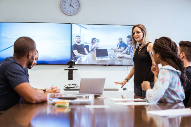 kolleginnen und kollegen diskutieren während der videokonferenz im tagungsraum - conference call business meeting presentation stock-fotos und bilder