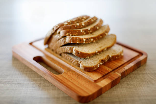 A DSLR Canon full frame photo of sliced Brazilian whole grain loaf bread over wooden board on woden table.
