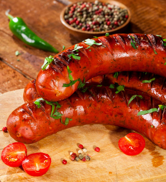 istock Grilled sausages on wooden background 1017663552