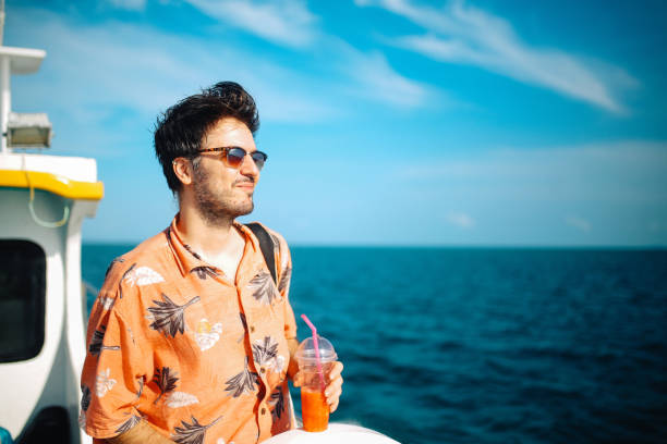 Young man relaxing on the boat while traveling in between Thai islands
