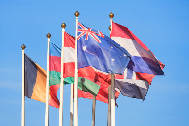 istock Flags of different countries flutters in the wind a background of bright blue sky 1017670440