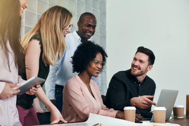 istock Smiling colleagues working together around a desk in an office 1017676100