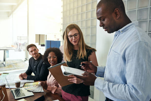 istock Smiling work colleagues talking business together in an office 1017676104