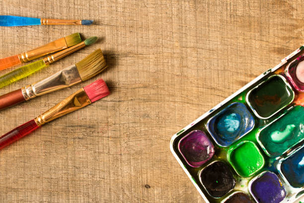 istock Various brushes and paints on the old wooden table . The view from the top. Creative concept 1017677290