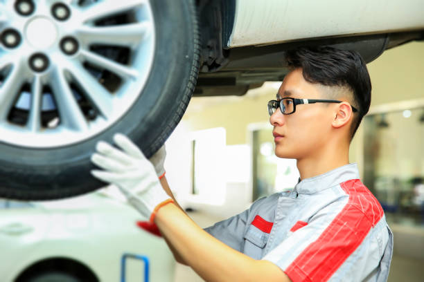 istock Asian auto repair worker checking tires 1017679754