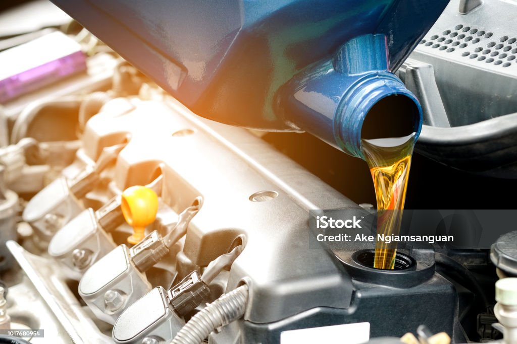 Refueling and pouring oil into the engine motor car. Energy fuel concept. Car Stock Photo