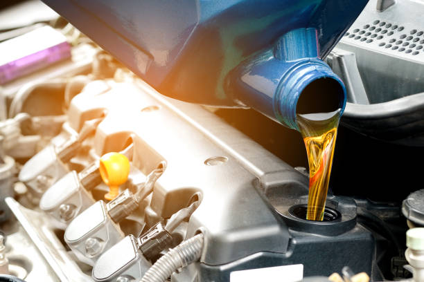 refueling and pouring oil into the engine motor car. energy fuel concept. - lubrication imagens e fotografias de stock
