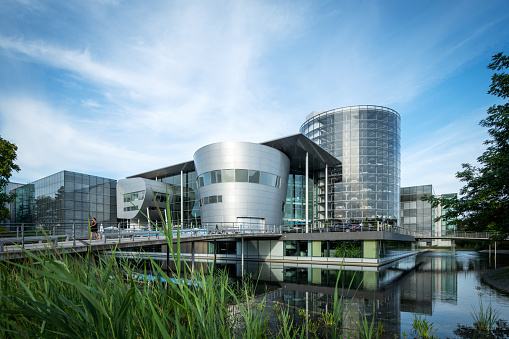 Dresden, Germany - August 07, 2018: The Transparent Factory of the German carmaker Volkswagen, designed by architect Gunter Henn in 2002 as a factory for cars and an exhibition space in Dresden. In 2016 it was reopened for a new electro mobility car.