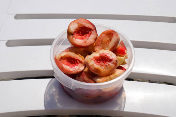 una tazza di pesche su una sdraio. mangiare frutta sul mare - beach table peach fruit foto e immagini stock