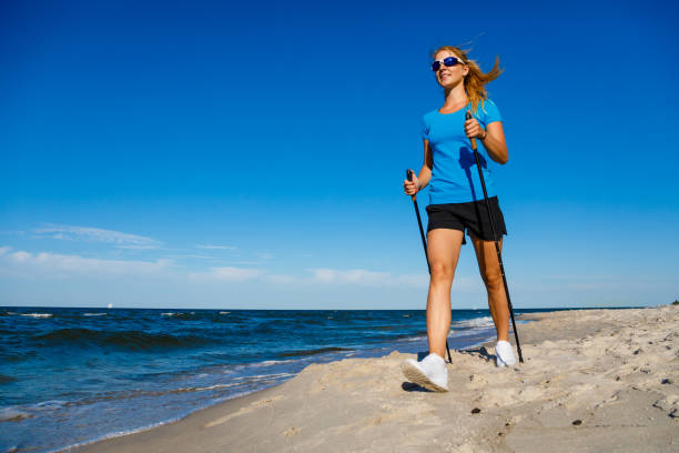 ノルディックウォー キング-女性の海辺でトレーニング - nordic walking walking relaxation exercise women ストックフォトと画像