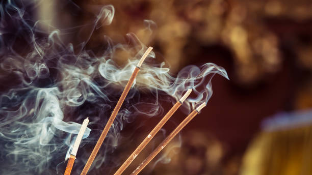 istock Burning incense sticks with smoke over dark background 1017707166