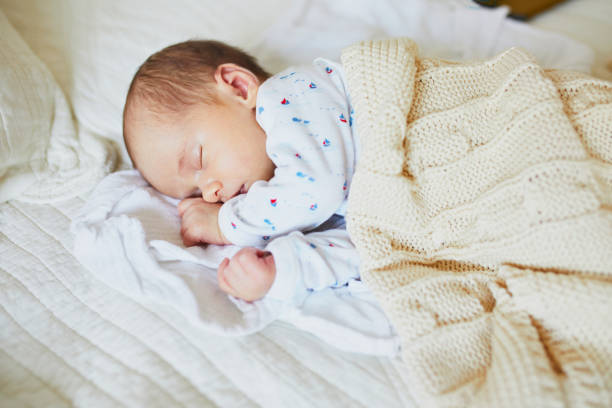 istock 1 month old baby girl sleeping under knitted blanket 1017719056