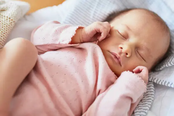 Newborn baby girl sleeping peacefully in the crib