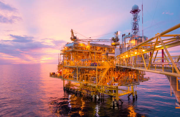 istock Offshore construction platform for exploration and production oil and gas with bridge in evening time for power energy of the world concept. 1017721866