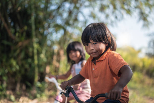 istock Two Children Riding a Bicycle in a Rural Place 1017724256