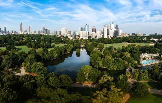City skyline of Atlanta with Piedmont Park and the lake in the morning sun.