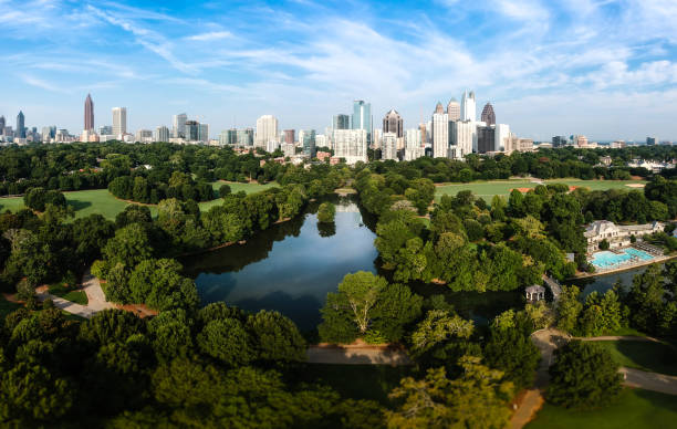 Atlanta Skyline with lake Lake Clara City skyline of Atlanta with Piedmont Park and the lake in the morning sun. atlanta georgia stock pictures, royalty-free photos & images