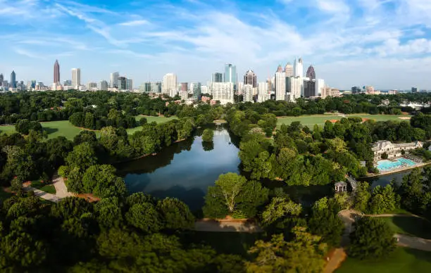 City skyline of Atlanta with Piedmont Park and the lake in the morning sun.
