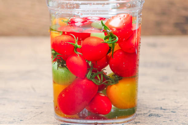 istock Ripe cherry tomatoes in bowl on wood board. 1017735864
