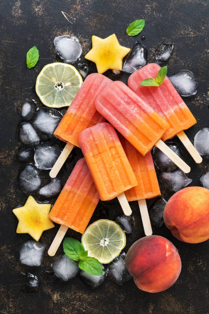 istock Flat lay peach popsicles. Yellow-red fruit ice cream. Summer dessert. 1017738542