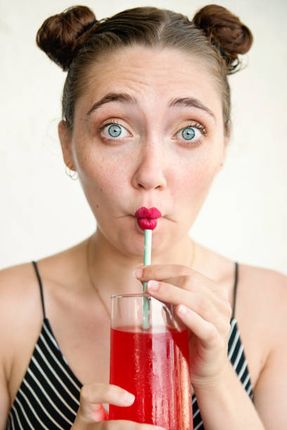istock Young adult woman using paper straw. 1017751436