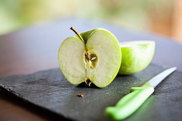 Slice of Green apples on black slate Slice of Green apples on black slate green apple slice overhead stock pictures, royalty-free photos & images