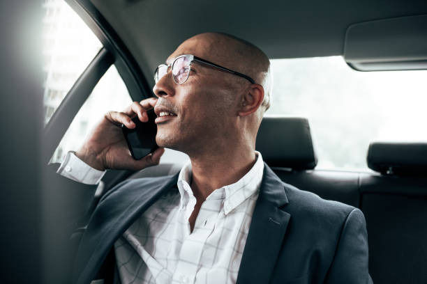istock Businessman talking on mobile phone sitting in car 1017778928