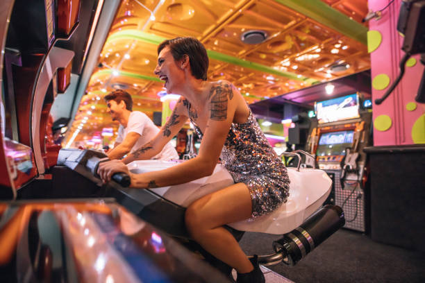 istock Couple playing an arcade racing game sitting on bikes 1017781256