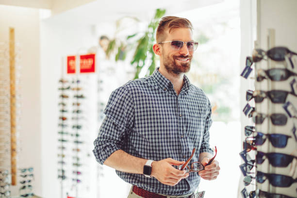 istock Young man buying sunglasses at the optical store 1017790942
