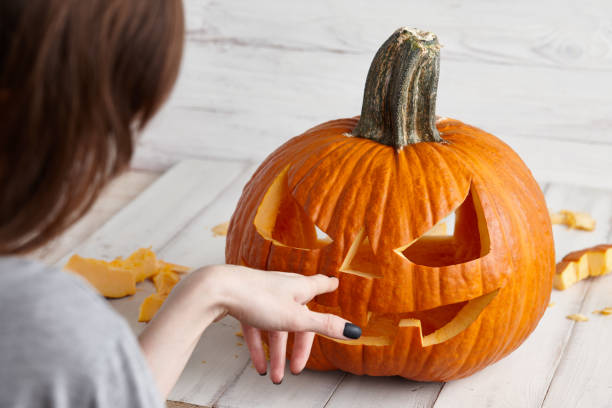 istock Carving halloween pumpkin into jack-o-lantern, close up view 1017795904