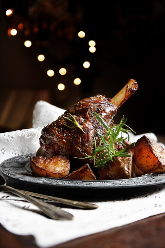 Traditionally cooked Leg of Lamb, also termed Lamb Shank, together with slow cooked roasted potatoes with rosemary and crushed garlic. Generous accommodation for copy space.