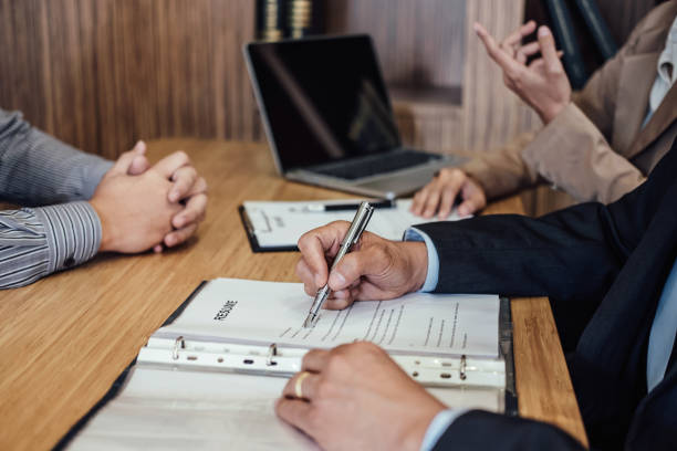istock Two senior manager reading a resume during a job interview, Employer interviewing to ask young male job seeker for recruitment talking in office 1017800924