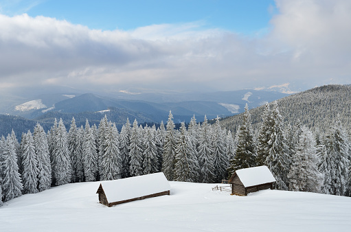 Winter daytime landscape with huts in the mountain valley. Carpathian Mountains, Ukraine, Europe