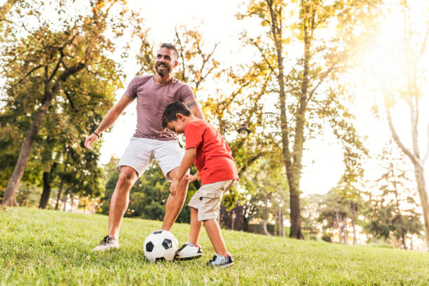 istock Father and son playing soccer in lawn 1017845676