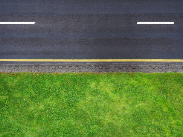 Highway background, roadside top view. Road view from above, black asphalt, white dividing strip, yellow stripe. Green roadside lawn, a pedestrian cobbled path Highway background, roadside top view. Road view from above, black asphalt, white dividing strip, yellow stripe. Green roadside lawn, a pedestrian cobbled path curb photos stock pictures, royalty-free photos & images
