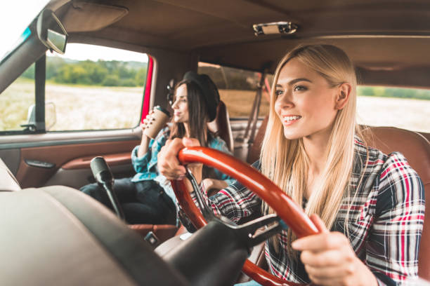 istock happy young girlfriends having car trip and riding through fields 1017887978