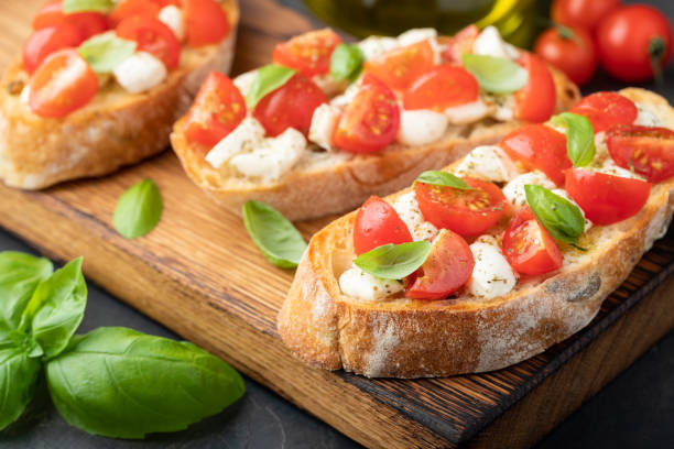 istock Bruschetta with tomatoes, mozzarella cheese and basil on a cutting board. Traditional italian appetizer or snack, antipasto 1017891048