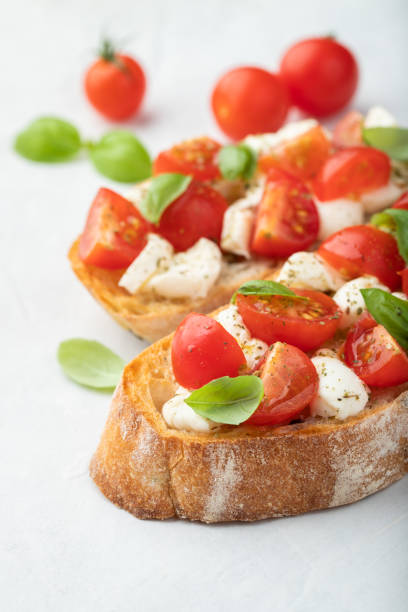 istock Bruschetta with tomatoes, mozzarella cheese and basil on a light background. Traditional italian appetizer or snack, antipasto 1017891052