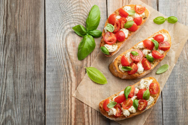 istock Bruschetta with tomatoes, mozzarella cheese and basil on a old rustic table. Traditional italian appetizer or snack, antipasto. Top view with copy space. Flat lay 1017891068