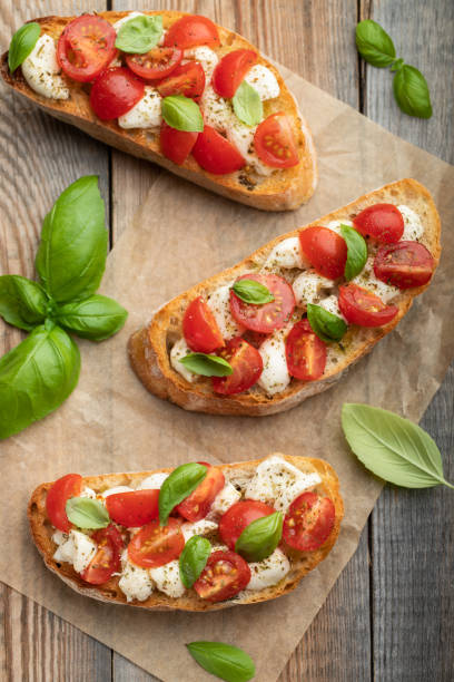 istock Bruschetta with tomatoes, mozzarella cheese and basil on a old rustic table. Traditional italian appetizer or snack, antipasto. Top view. Flat lay 1017891086