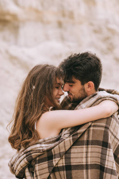 istock young tender couple in blanket hugging together 1017898724